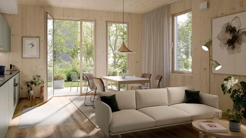 Heller offener Wohn-Essbereich mit Holzwänden, Parkettboden und Zugang zu einem grünen Garten.
