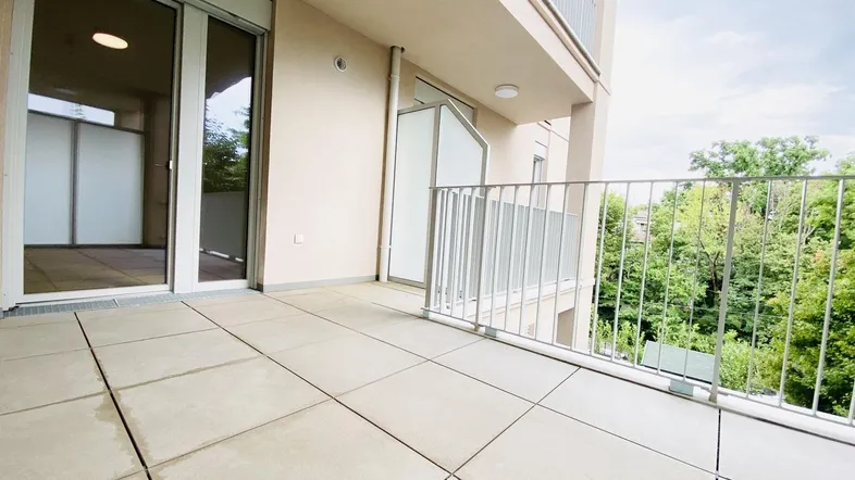 Geräumiger Balkon mit Fliesenboden und Blick ins Grüne, ideal für entspannte Stunden im Freien.