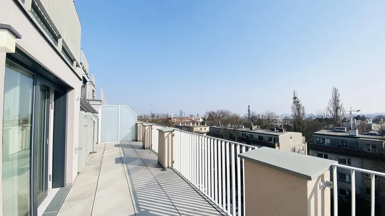 Große Dachterrasse mit weitem Blick über die Stadt und umliegende Gebäude.