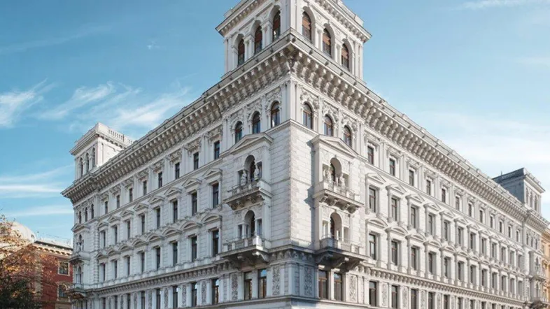 Elegantes historisches Gebäude mit klassischer Architektur und vielen Fenstern an einer belebten Straßenecke.