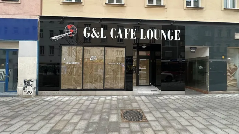 Fassade eines Cafés mit großen Schaufenstern und dem Schriftzug "G&L CAFE LOUNGE" an der Front.