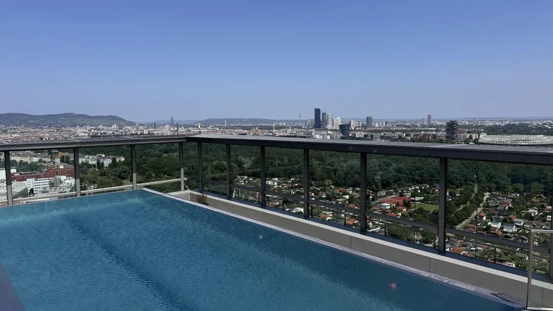 Infinity-Pool auf dem Dach mit atemberaubendem Blick über die Stadt und die umliegende Landschaft.