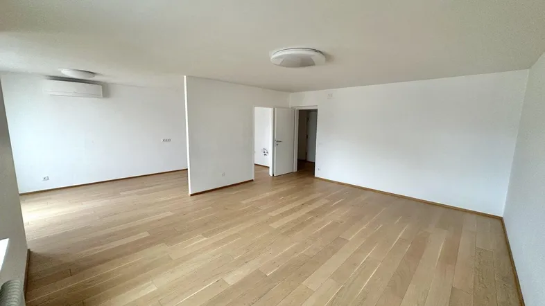 Geräumiger, heller Wohnbereich mit neuem Parkettboden und Klimaanlage.