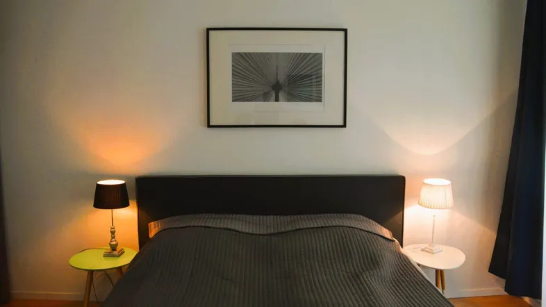 Gemütliches Schlafzimmer mit Doppelbett, Nachttischen und stimmungsvoller Beleuchtung.