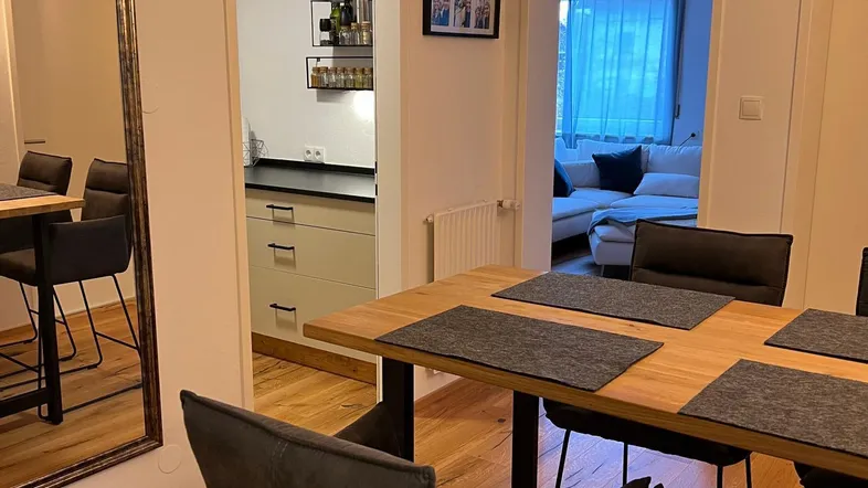 Moderner Essbereich mit Holzboden, der in die Küche und das Wohnzimmer übergeht.