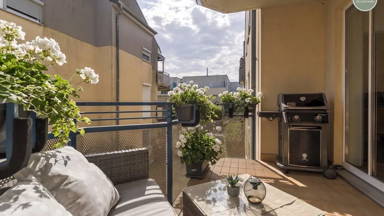 Gemütlicher Balkon mit Sitzgelegenheiten, Pflanzen und Grill für entspannte Stunden im Freien.