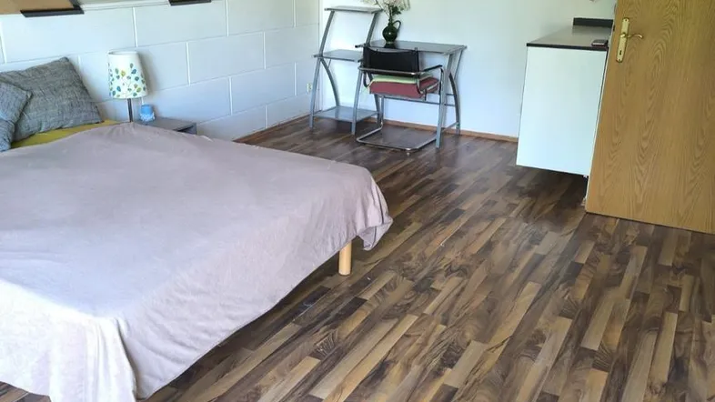 Gemütliches Schlafzimmer im Dachgeschoss mit Holzboden und schräger Decke, ideal für ruhige Nächte.