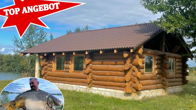 Rustikales Blockhaus am Seeufer mit braunem Dach, umgeben von Natur und einem 'Top Angebot' Aufkleber.