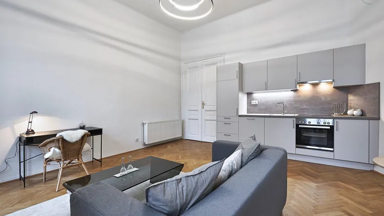 Heller Wohn- und Essbereich mit integrierter Küchenzeile, Parkettboden und modernem Design.