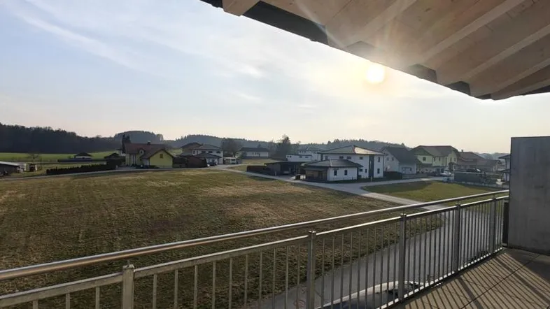 Sonniger Balkon mit Weitblick über Felder und die ländliche Umgebung.