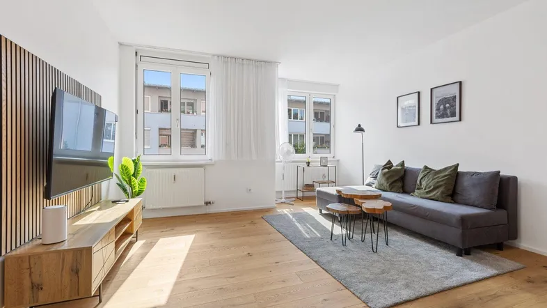 Helles Wohnzimmer mit modernem Design, Holzboden und bequemer Couch.