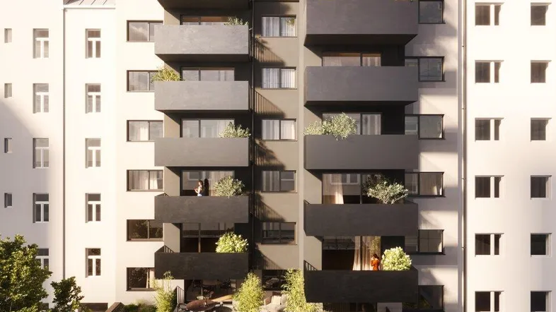 Moderne Wohnanlage mit dunklen Balkonen, begrünten Terrassen und einem grünen Innenhof.