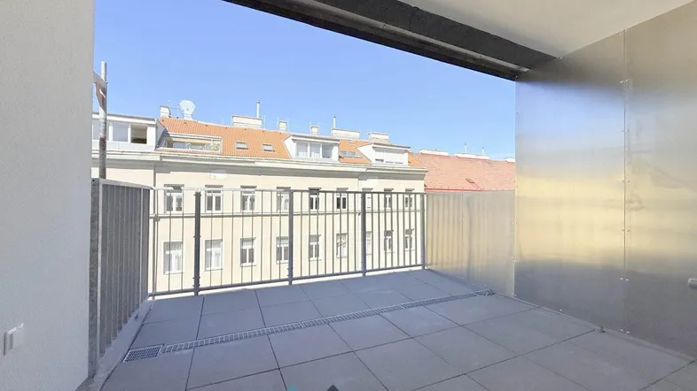 Geräumiger Balkon mit Fliesenboden und Blick auf die umliegenden Gebäude der Stadt.