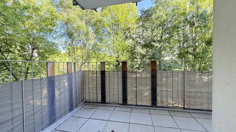 Geräumiger Balkon mit Fliesenboden und Blick ins Grüne, ideal für entspannte Stunden im Freien.