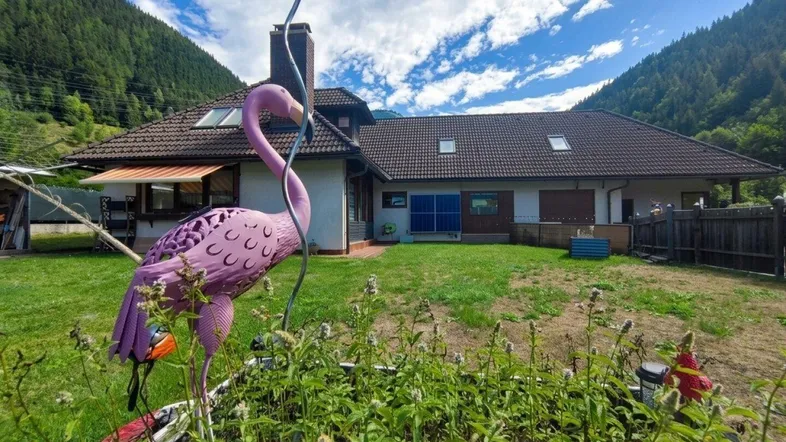 Gepflegter Gartenbereich hinter dem Haus mit Blick auf die umliegende Berglandschaft.