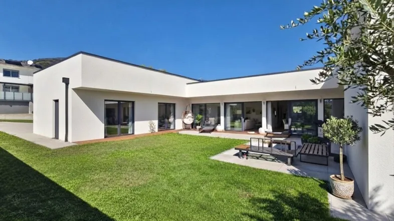 Modernes Einfamilienhaus mit gepflegtem Rasen und einer kleinen Terrasse für entspannte Stunden im Freien.