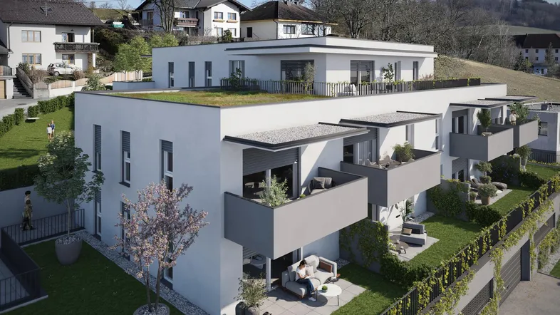 Moderne Wohnanlage mit Terrassen, Balkonen und begrünten Außenbereichen in sonniger Hanglage.