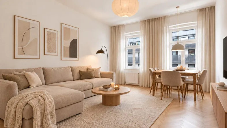 Helles, modern eingerichtetes Wohn-Esszimmer mit beigem Sofa, Holzboden und einem Esstisch für vier Personen.