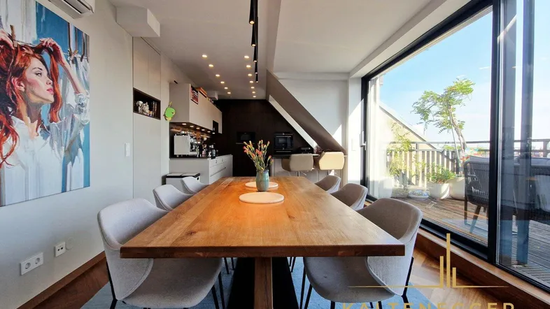 Heller offener Wohn-Essbereich mit Holztisch, modernen Stühlen und Zugang zur Dachterrasse.