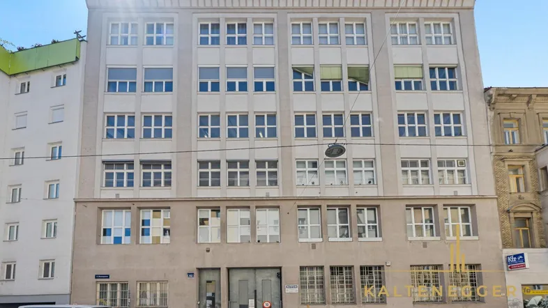 Mehrstöckiges Gebäude mit zahlreichen Fenstern und schlichter Fassadengestaltung in der Stadt.