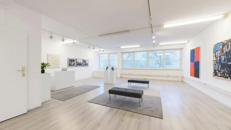 Heller, offener Gewerberaum mit großen Fenstern, ideal als Galerie oder Ausstellungsfläche.