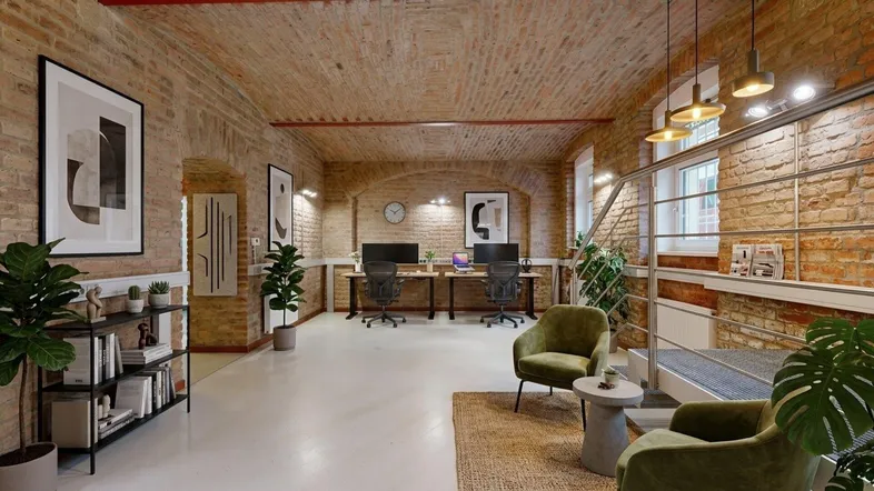 Geräumiges Büro mit freiliegenden Ziegelwänden, Gewölbedecke und modernen Arbeitsplätzen.