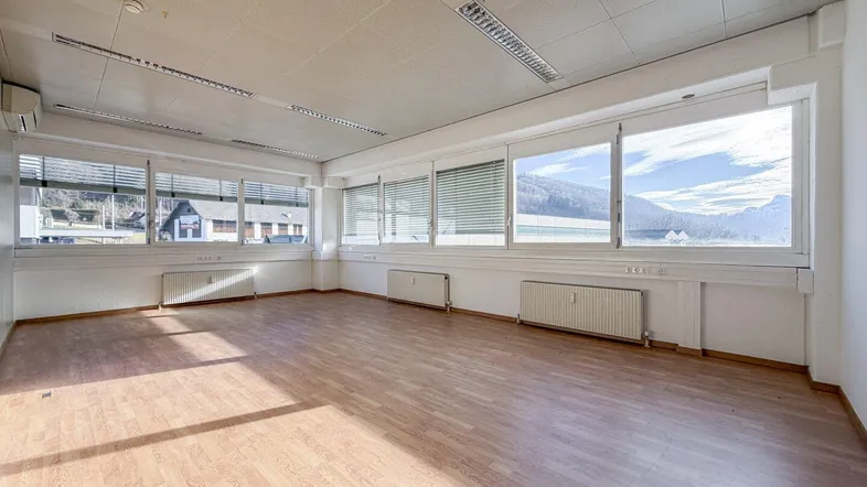 Geräumiger Büroraum mit Laminatboden, Klimaanlage und weitem Blick auf die Berge und Landschaft.