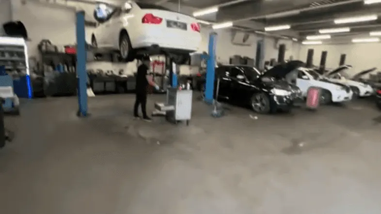Geräumige Autowerkstatt mit Hebebühnen und mehreren Fahrzeugen, die auf Reparatur warten.