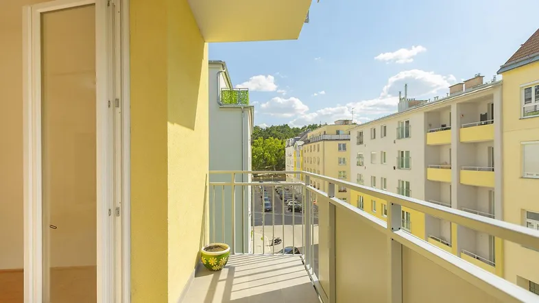 Heller Balkon mit Blick auf die Straße und umliegende Gebäude.