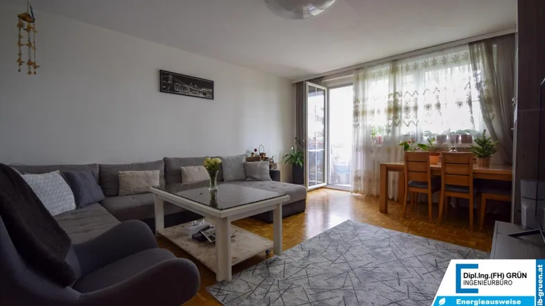 Geräumiger Wohn-Essbereich mit Ecksofa, Esstisch und Zugang zum Balkon.