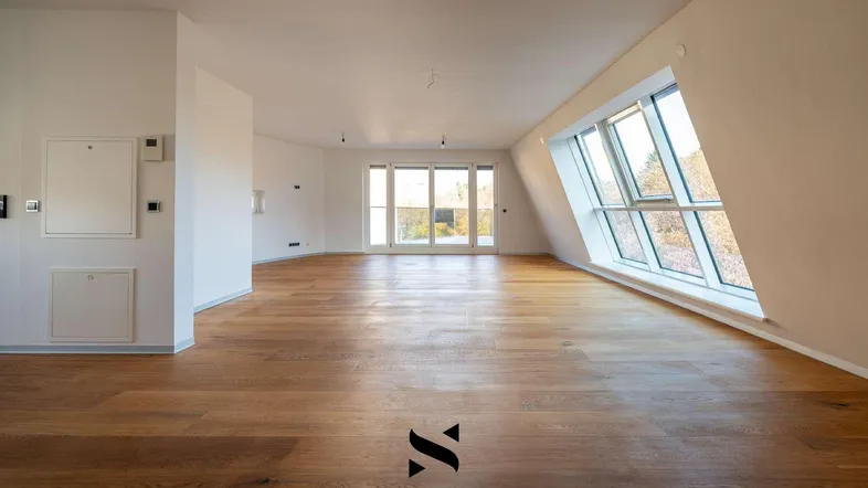 Helles, leeres Zimmer mit Holzboden, großen Fenstern und Zugang zu einem Außenbereich.