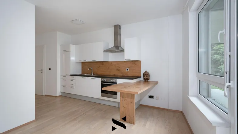 Moderne Küche mit weißen Schränken, Holzakzenten und einem Esstisch am großen Fenster.