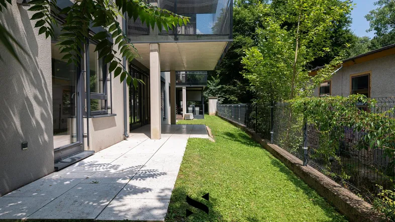 Eine moderne Terrasse mit direktem Zugang zum Garten und Blick auf die grüne Umgebung.