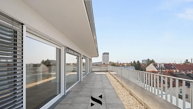 Weitläufige Dachterrasse mit modernen Fliesen und Panoramablick auf die städtische Umgebung.
