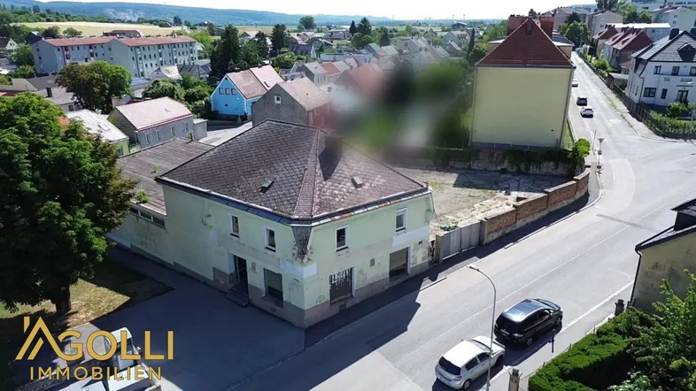 Luftaufnahme eines älteren Gebäudes mit umliegendem Grundstück und Blick auf die Nachbarschaft.