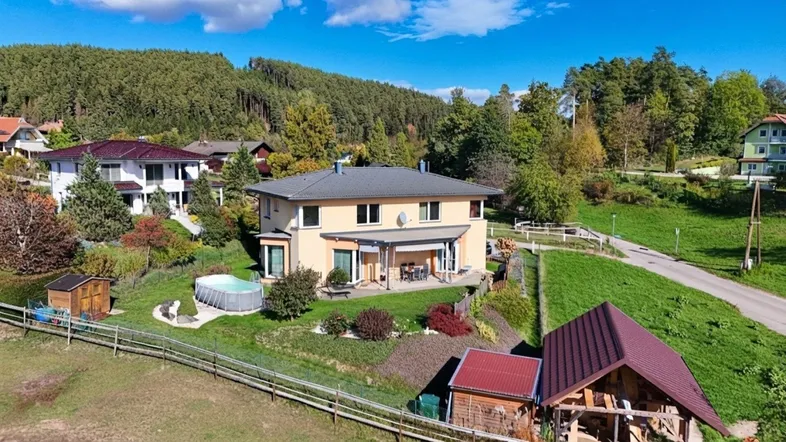 Luftaufnahme des Hauses mit Garten, Pool und umliegender grüner Landschaft.