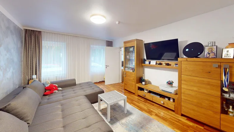 Gemütliches Wohnzimmer mit großem Ecksofa, Holzboden und modernem TV-Möbel.