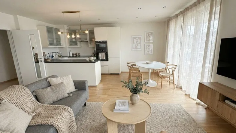 Helles, offenes Wohnzimmer mit integrierter Küche, Essbereich und modernem Design.