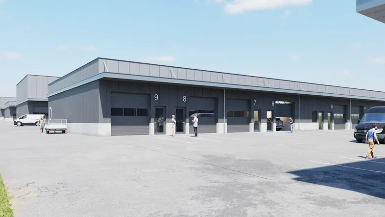 Moderne Gewerbeimmobilie mit mehreren Einheiten, Rolltoren und großzügigen Parkflächen für Fahrzeuge.