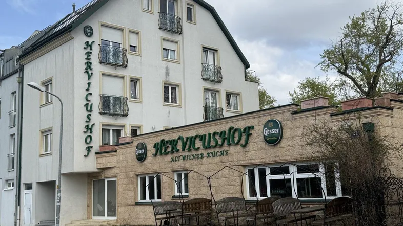 Fassade eines Gebäudes mit Restaurant im Erdgeschoss und Balkonen in den oberen Etagen.