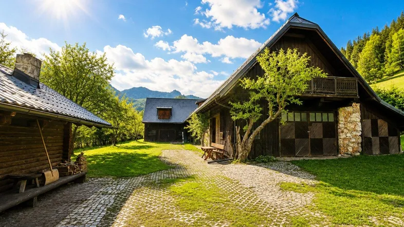 Rustikales Holzhaus mit gepflastertem Hof und grüner Umgebung unter strahlendem Sonnenschein.