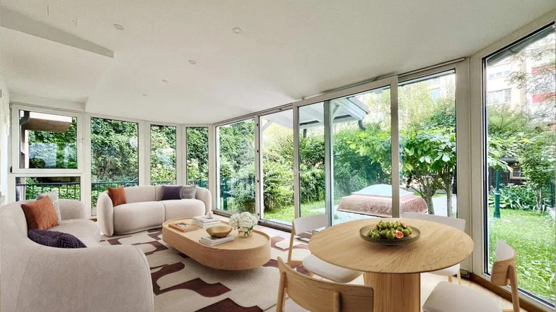 Helles Wohn- und Esszimmer mit großen Glasfronten und Blick auf den grünen Garten.