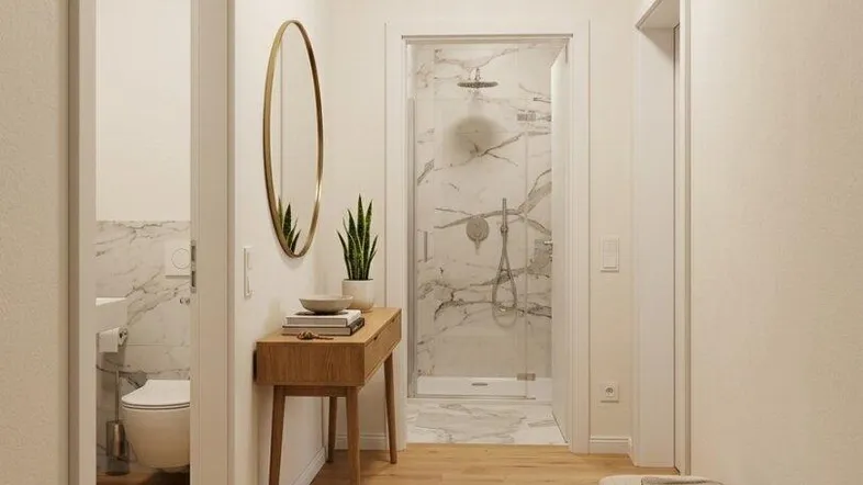 Heller Flur mit Holzboden, einem dekorativen Spiegel und Zugang zu Bad und WC.