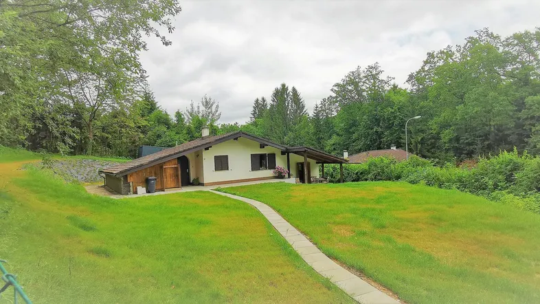 Ein charmantes Einfamilienhaus in ländlicher Umgebung, umgeben von viel Grün und Bäumen.