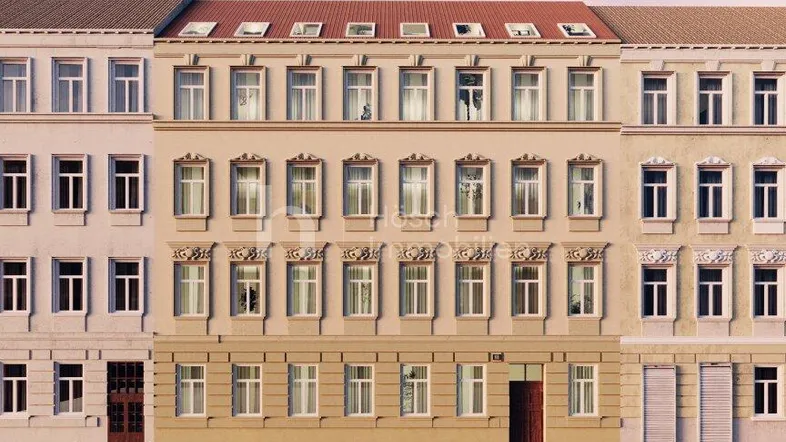 Mehrere Gebäude mit klassischer Fassade und parkenden Autos auf der Straße unter blauem Himmel.