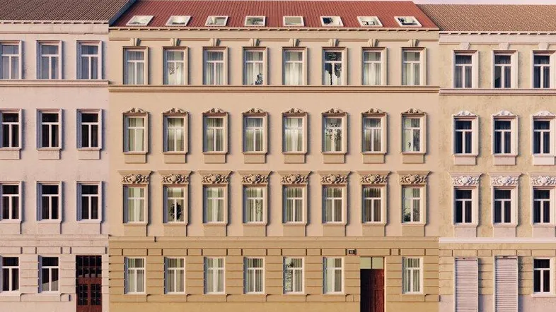 Ansicht der modernen Fassade eines Mehrfamilienhauses mit geparkten Autos auf der Straße.