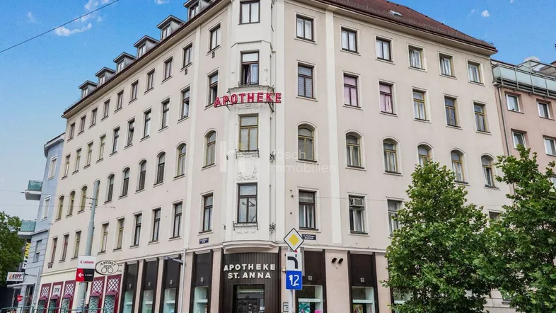 Eckgebäude mit Apotheke im Erdgeschoss und klassischer Architektur in städtischer Umgebung.