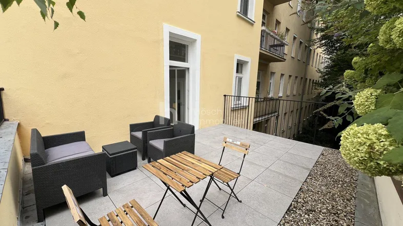 Gemütliche Terrasse mit Sitzgelegenheiten und Blick auf die umliegende Bebauung.