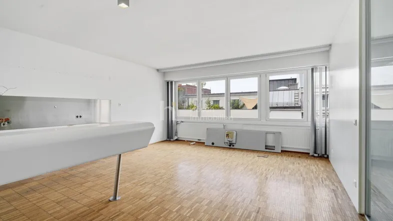 Heller, offener Büroraum mit Parkettboden und großen Fenstern, ideal für flexible Nutzung.