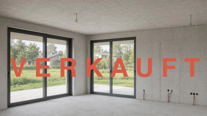 Unfertiger Innenraum mit großen Schiebetüren, Betonwänden und Blick ins Grüne, bereit für den Ausbau.